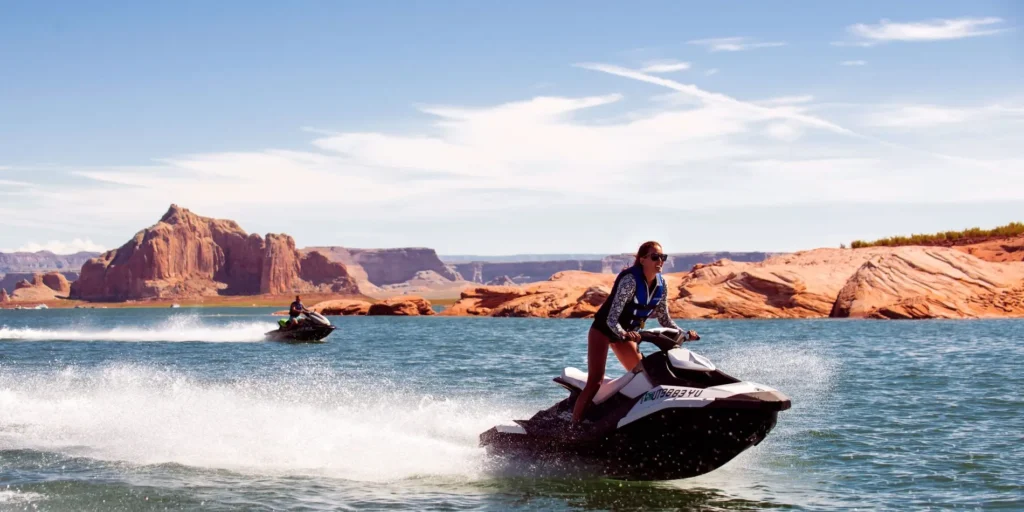 Two members of the Adventus Club enjoying jet skiing on the water.