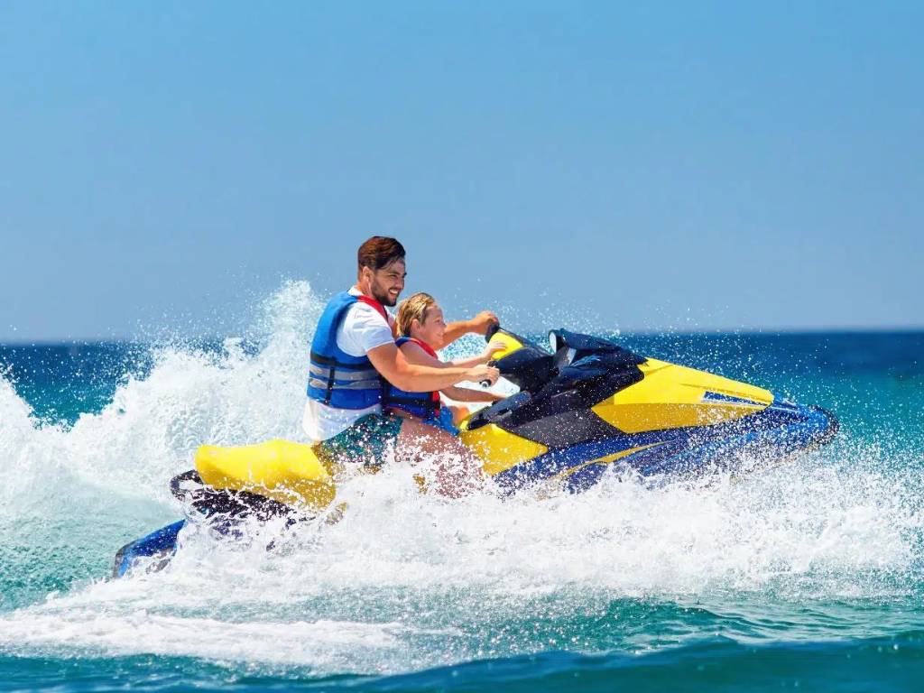 A rider learning safe techniques during a Jet Ski Safety Course on a calm lake.