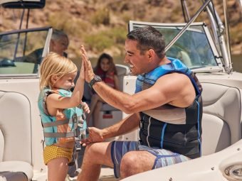 A father teaches his daughter about boating safety and the need for safety jackets.
